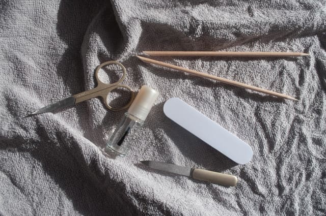 Nail clippers, pusher and a fresh file laid out on a clean towel