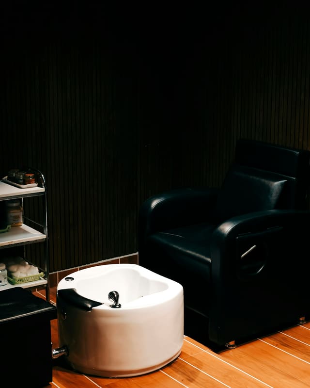 A pipe-less pedicure chair and basin in a quiet, dimly lit room